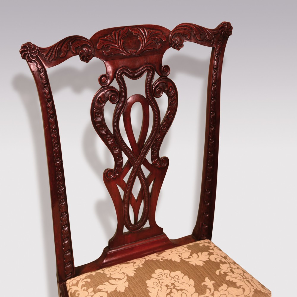 A pair of Georgian Chippendale carved mahogany single dining chairs featuring detailed pierced splats and patterned fabric upholstered seats. View IV