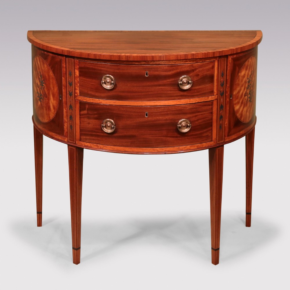 A late 18th-century Sheraton period demilune commode crafted from satinwood with floral marquetry panels and tapered legs. View II