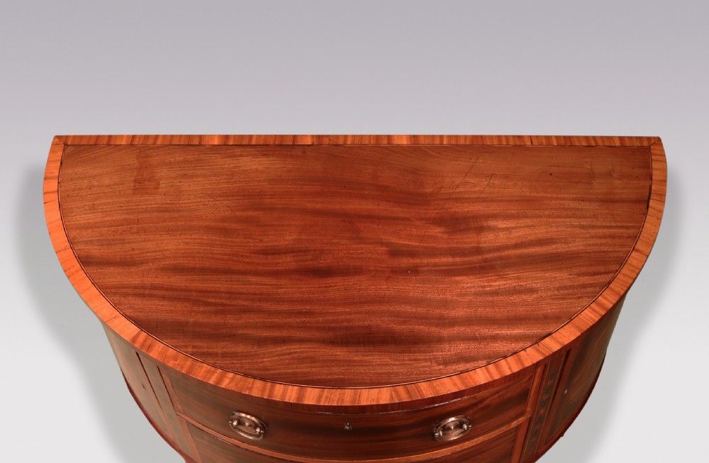 A late 18th-century Sheraton period demilune commode crafted from satinwood with floral marquetry panels and tapered legs. View III