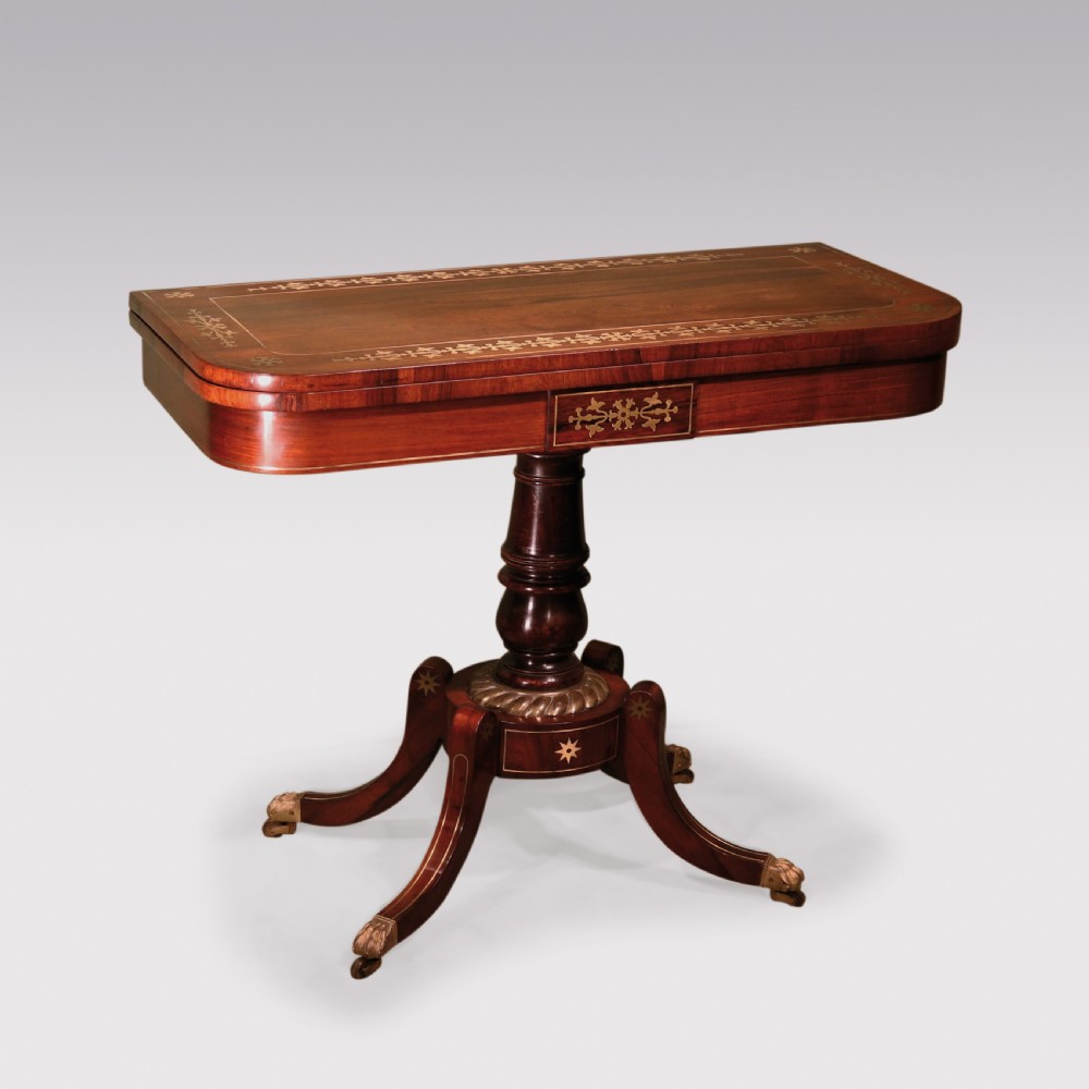 A pair of Regency period rosewood card tables featuring brass inlaid tops, turned central pedestals, and four splayed legs with brass paw feet. View II