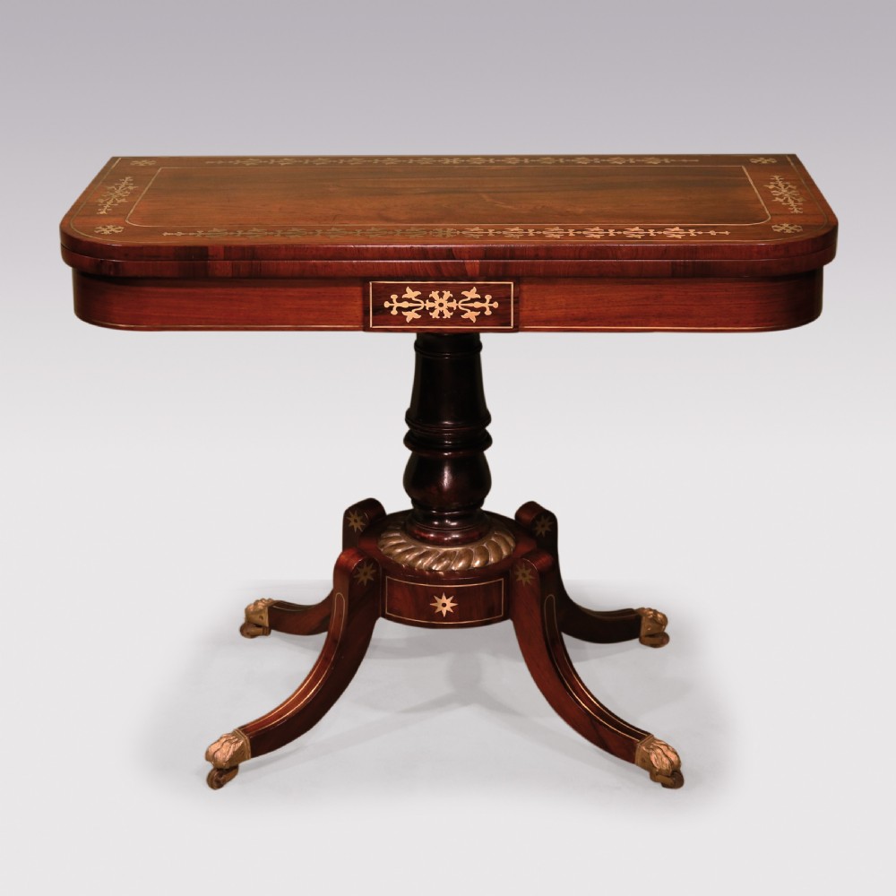 A pair of Regency period rosewood card tables featuring brass inlaid tops, turned central pedestals, and four splayed legs with brass paw feet. View VIII