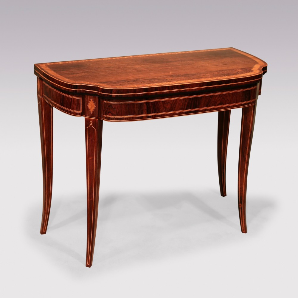 An antique Sheraton period rosewood fold-over card table featuring intricate marquetry stringing, diamond inlay accents, and tapered legs.