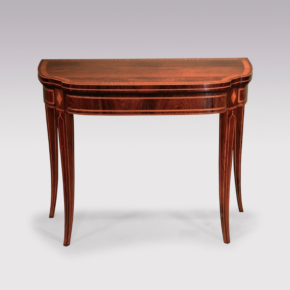 An antique Sheraton period rosewood fold-over card table featuring intricate marquetry stringing, diamond inlay accents, and tapered legs. View II
