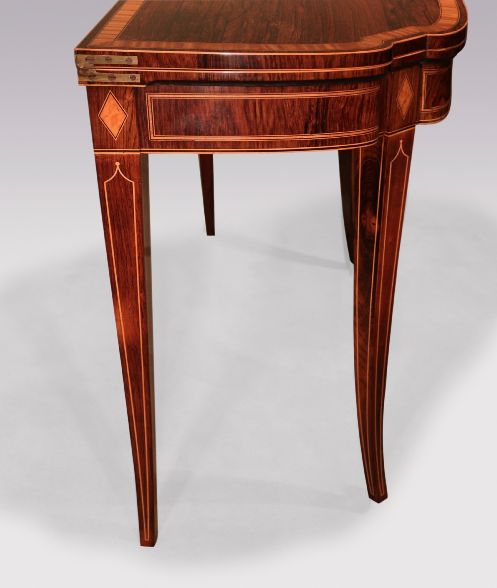 An antique Sheraton period rosewood fold-over card table featuring intricate marquetry stringing, diamond inlay accents, and tapered legs. View VI