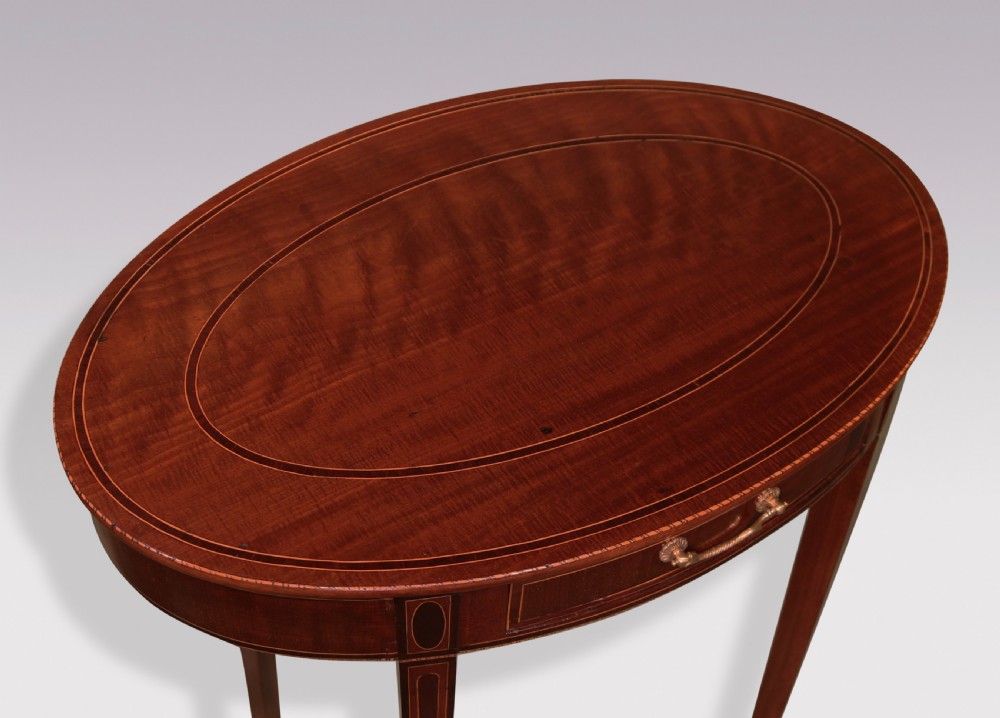 A pair of late 18th-century mahogany oval occasional tables featuring satinwood stringing, single frieze drawers with brass handles, and square tapered legs. View VII