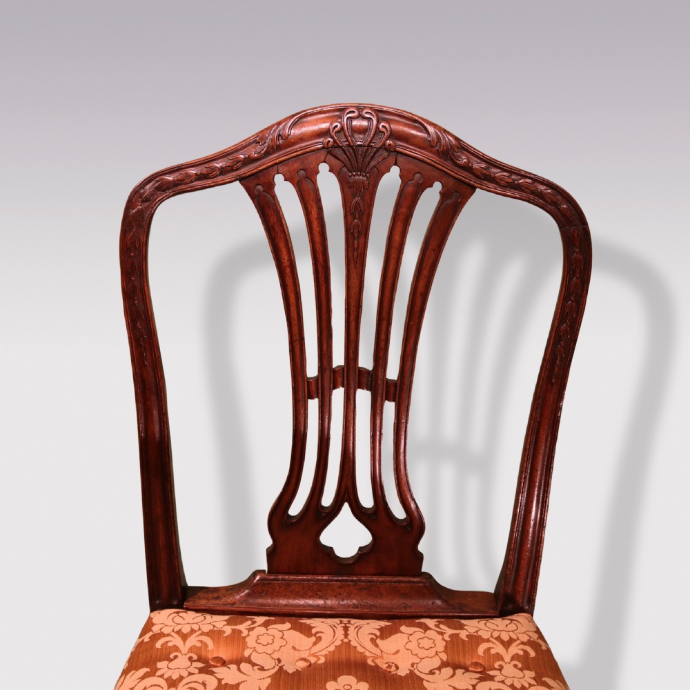 A pair of 18th-century Hepplewhite mahogany side chairs featuring pierced splat backs, serpentine seats upholstered in patterned terracotta damask, and square legs with H-stretchers. View IV
