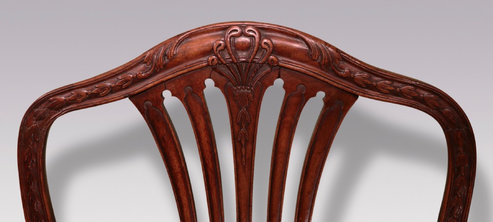 A pair of 18th-century Hepplewhite mahogany side chairs featuring pierced splat backs, serpentine seats upholstered in patterned terracotta damask, and square legs with H-stretchers. View V
