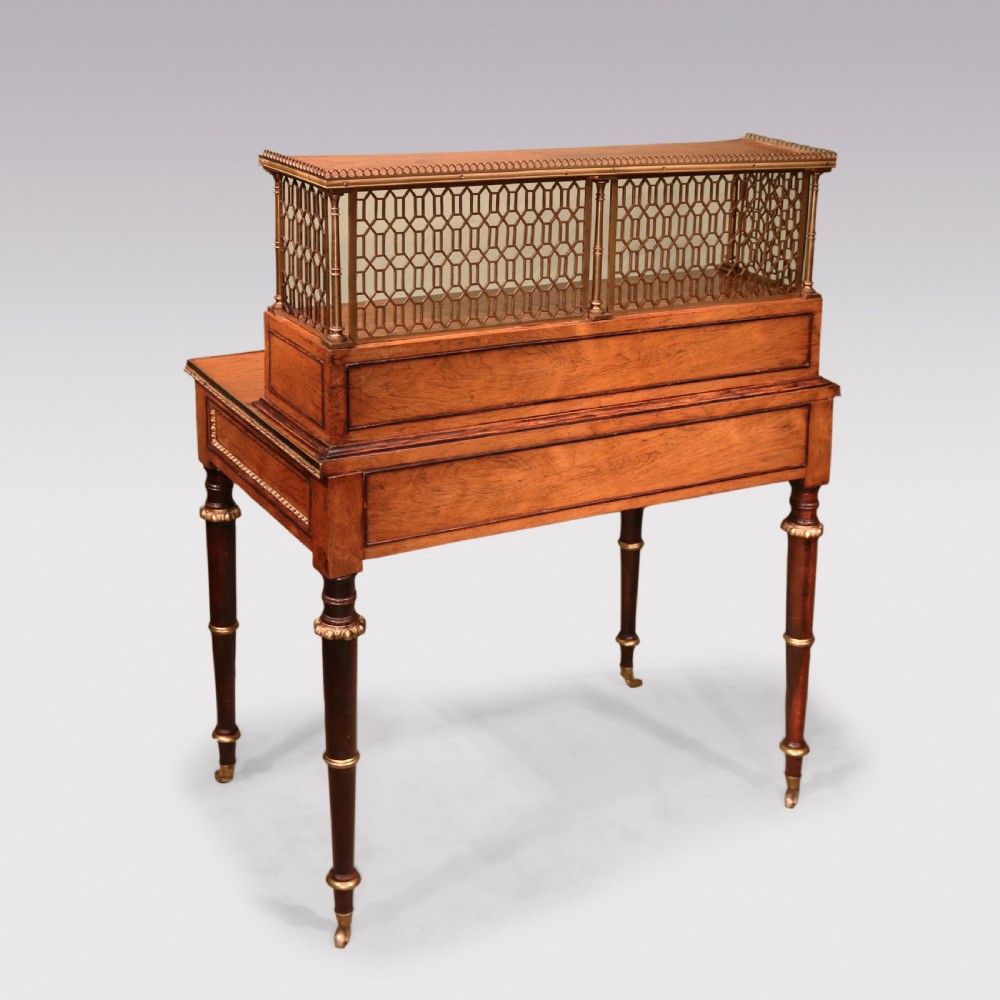 An early nineteenth-century rosewood bonheur du jour writing desk featuring a pierced brass gallery top, small drawers, brass mounts, and turned legs with castors. View VII