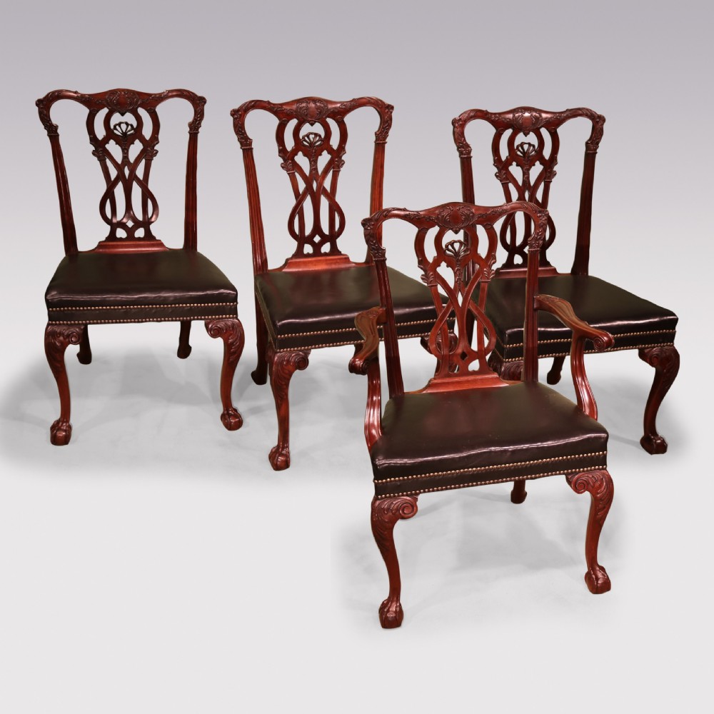 A set of eight mahogany dining chairs comprising six side chairs and two carvers with intricate pierced back splats, dark leather seats, and carved cabriole legs ending in ball and claw feet. View IX