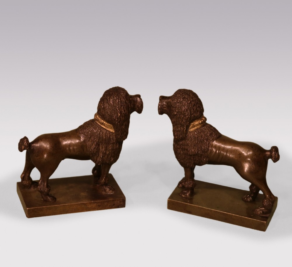 A pair of early 19th-century dark brown bronze poodle figures featuring gilded collars standing on rectangular bases. View II