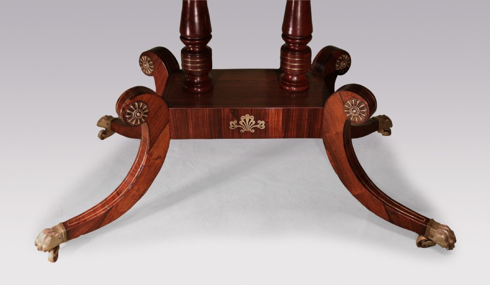 An antique Regency rosewood sofa table with intricate brass inlay, drop-leaf ends, shallow drawers, and swept legs on brass paw castors. View V