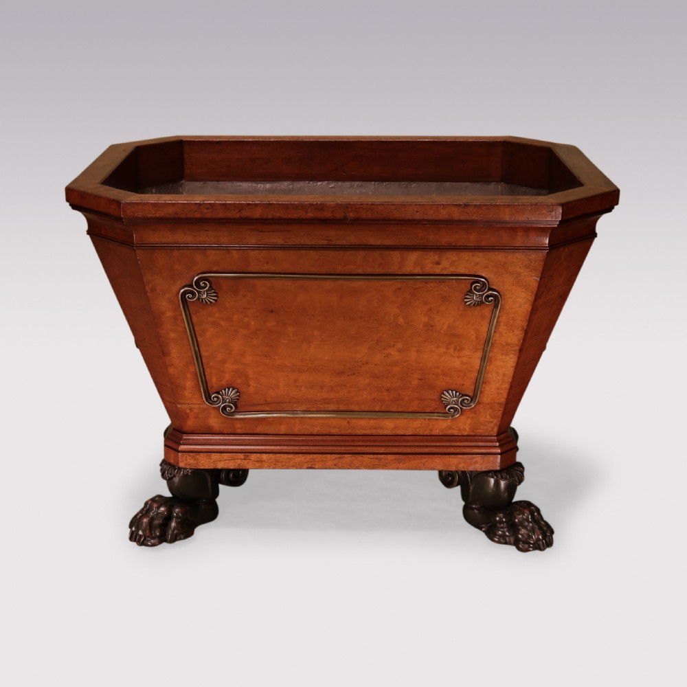 A Regency mahogany cellarette featuring tapered sides, brass inlay, brass lion mask handles, and carved claw feet. View II