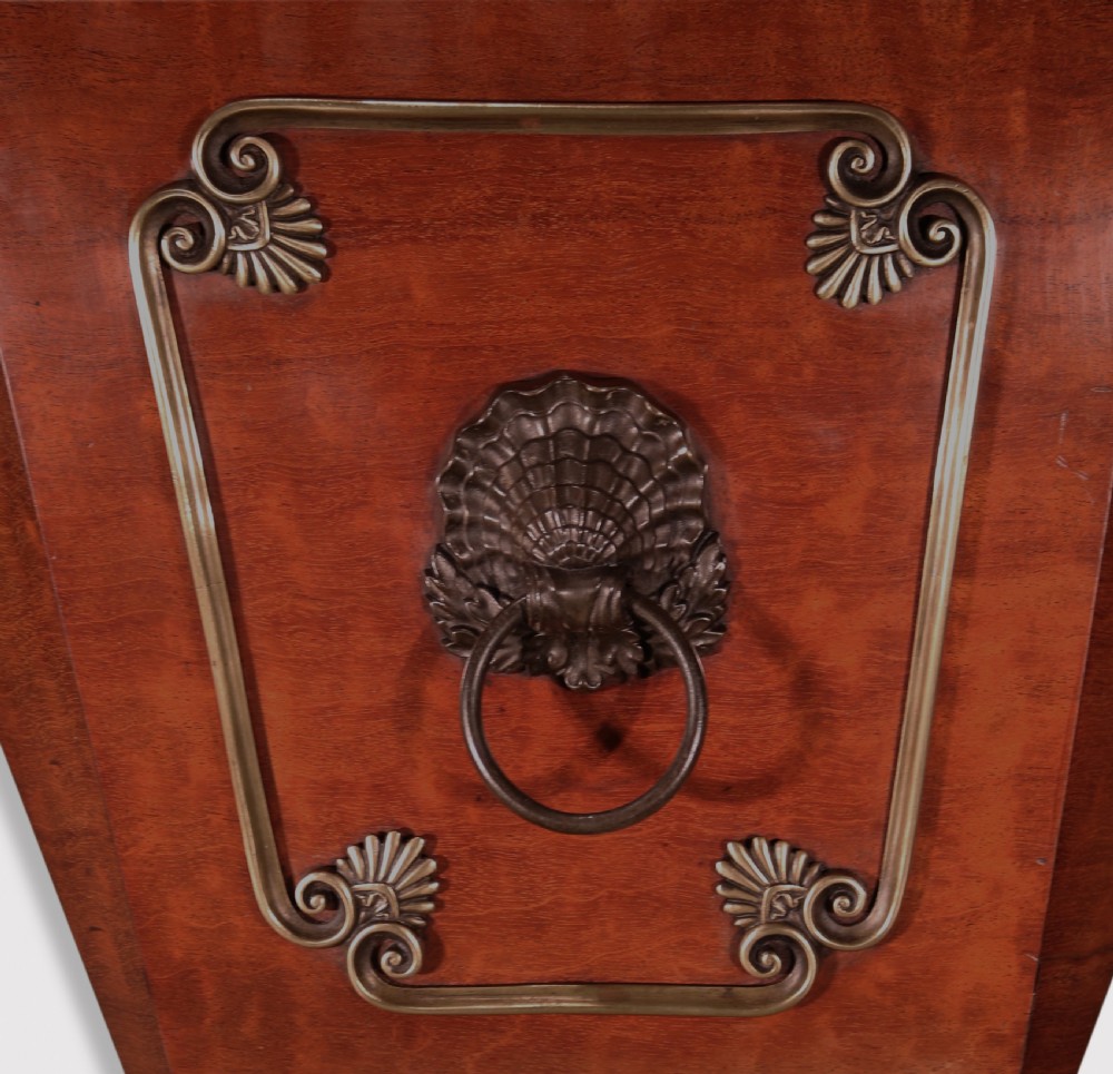 A Regency mahogany cellarette featuring tapered sides, brass inlay, brass lion mask handles, and carved claw feet. View III