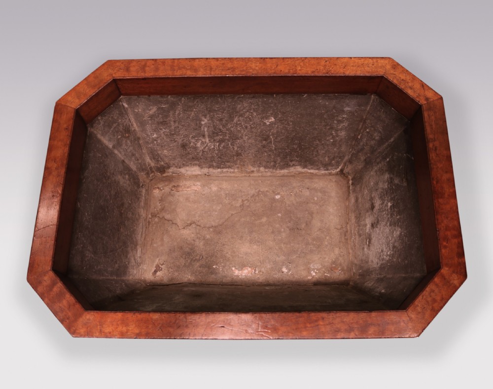 A Regency mahogany cellarette featuring tapered sides, brass inlay, brass lion mask handles, and carved claw feet. View V
