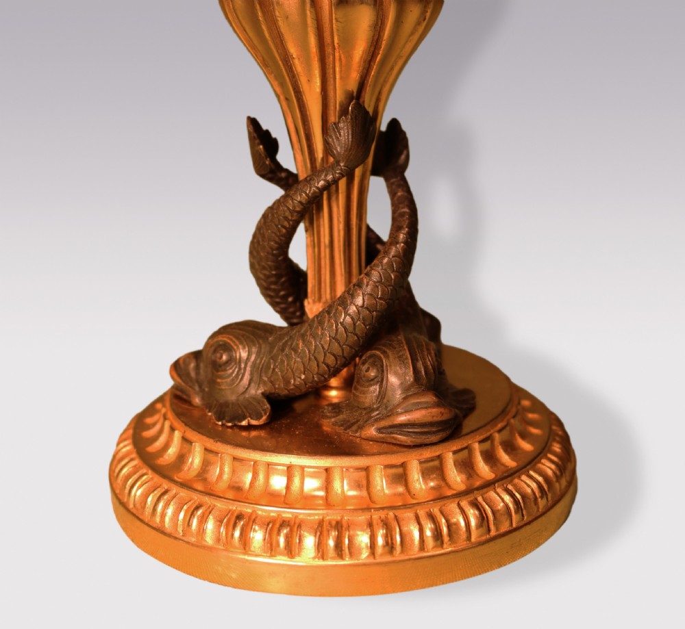 A pair of nineteenth-century gilt bronze and patinated bronze candlesticks featuring stylized dolphin figures wrapped around central fluted stems. View IV