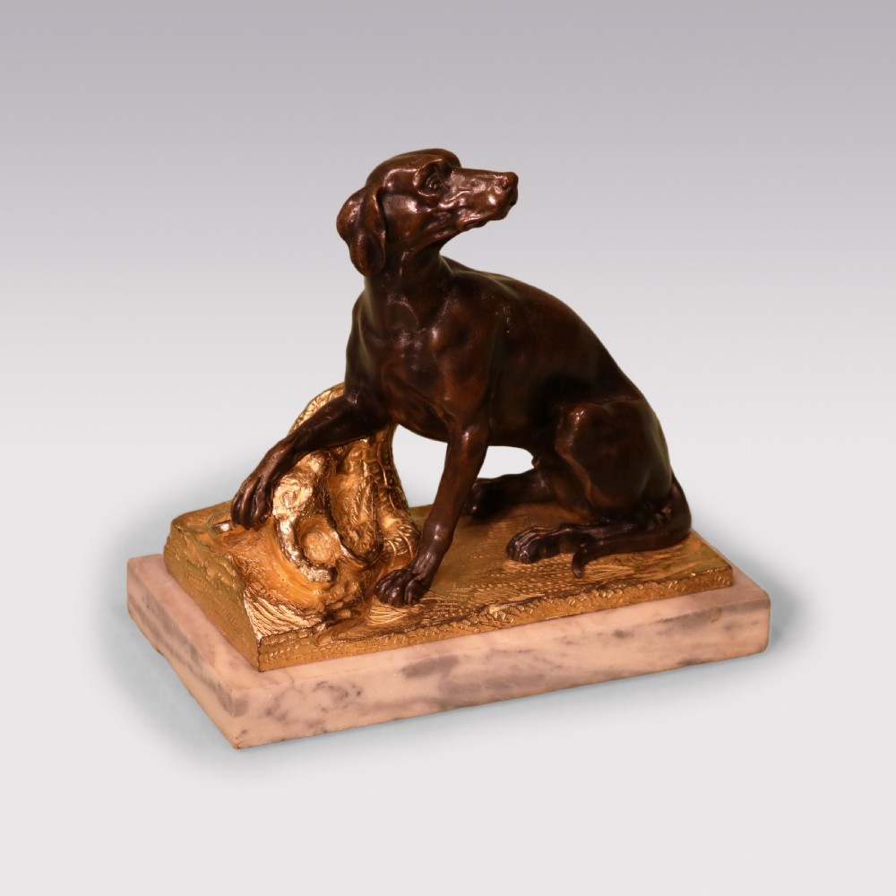 A pair of 19th-century dark bronze sculptures featuring seated hounds resting their paws on gilded ormolu bases depicting pheasants, mounted on rectangular marble plinths. View II