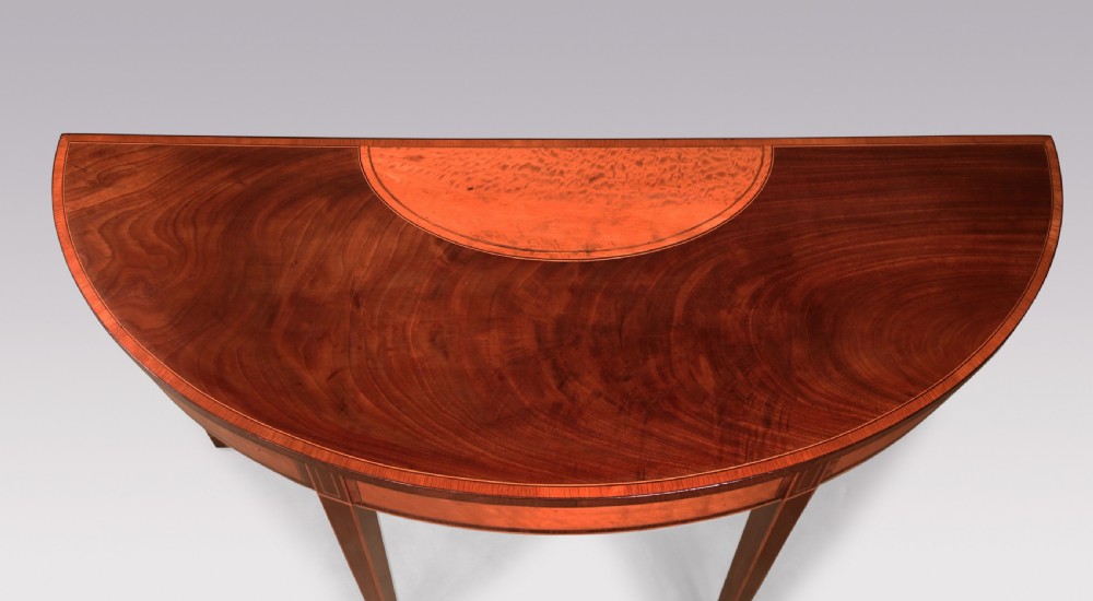 A demilune mahogany card table with satinwood crossbanding inlay and tapered square legs. View VI