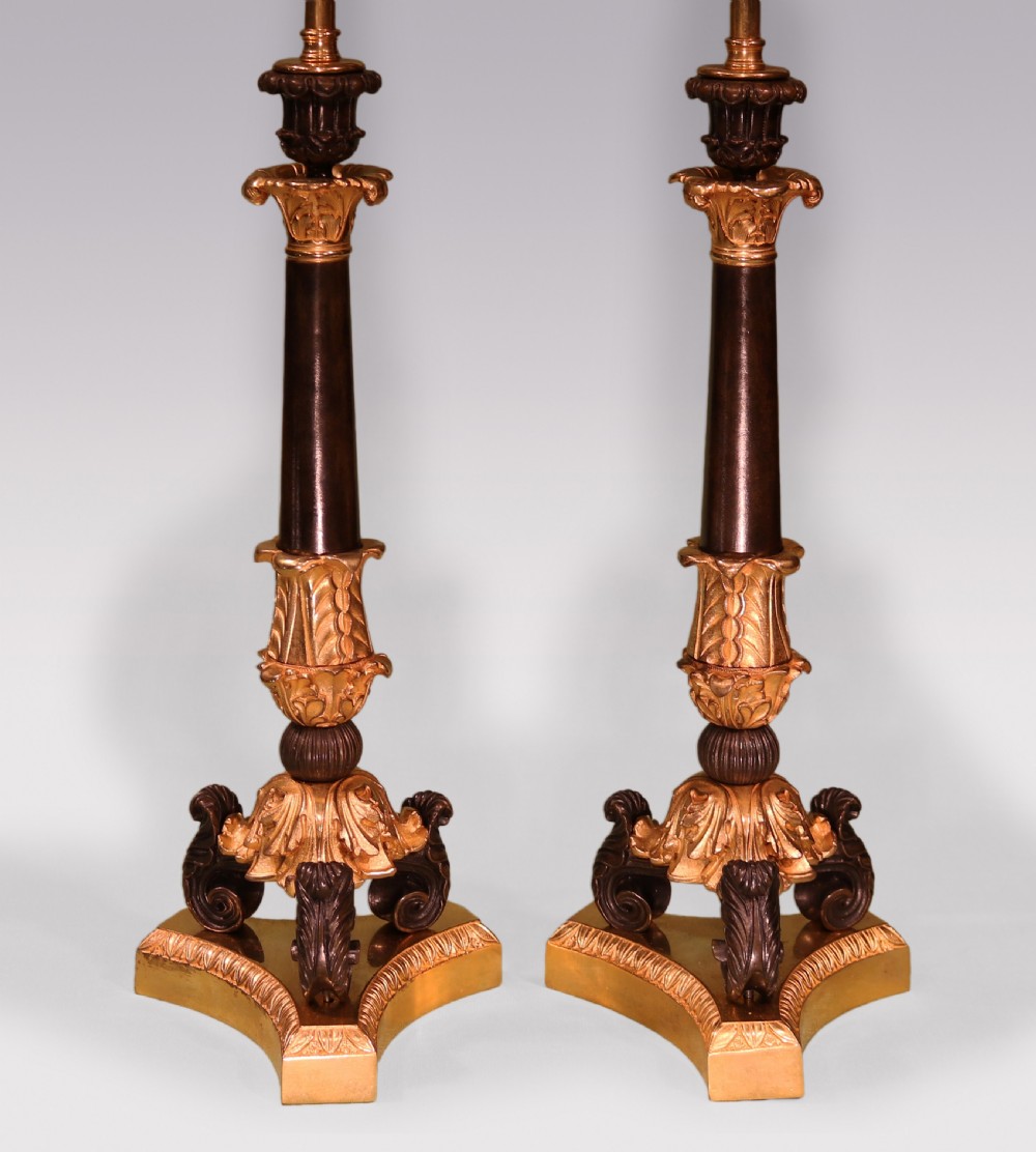 A pair of 19th-century Neoclassical table lamps featuring dark patinated bronze columns, ornate gilt-bronze acanthus leaf mounts, tripod scrolled bases, and flared fabric shades. View II