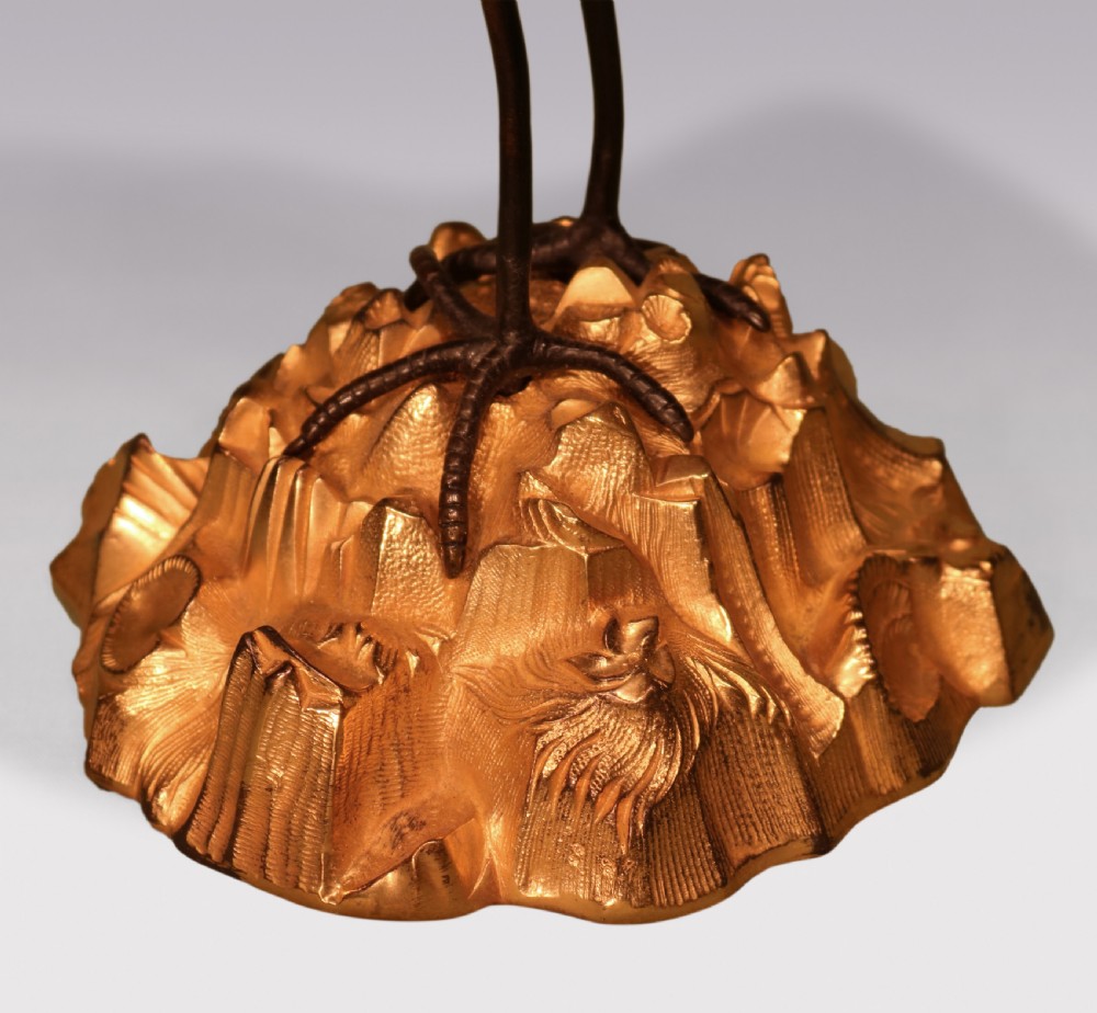 A pair of mid-19th century dark patinated bronze storks standing on rocky gilt ormolu bases, each holding a palm-leaf sconce in its beak. View VI