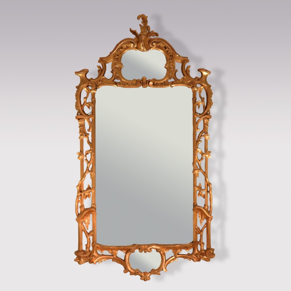 An antique Chippendale period rectangular wall mirror featuring an ornate carved giltwood frame with rococo scrollwork and foliage motifs.