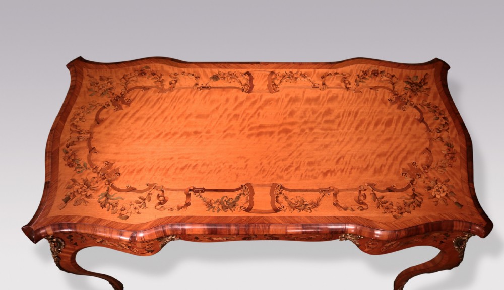 A mid-19th-century serpentine satinwood writing table featuring floral marquetry inlay, calamander banding, gilt-bronze mounts, and cabriole legs. View III