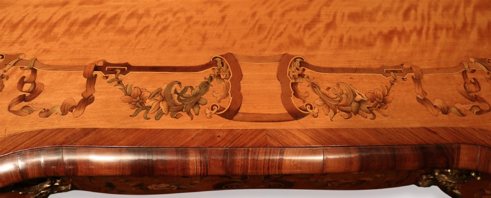 A mid-19th-century serpentine satinwood writing table featuring floral marquetry inlay, calamander banding, gilt-bronze mounts, and cabriole legs. View VI