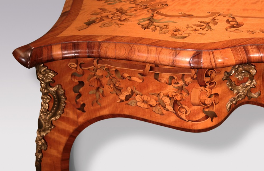 A mid-19th-century serpentine satinwood writing table featuring floral marquetry inlay, calamander banding, gilt-bronze mounts, and cabriole legs. View VII