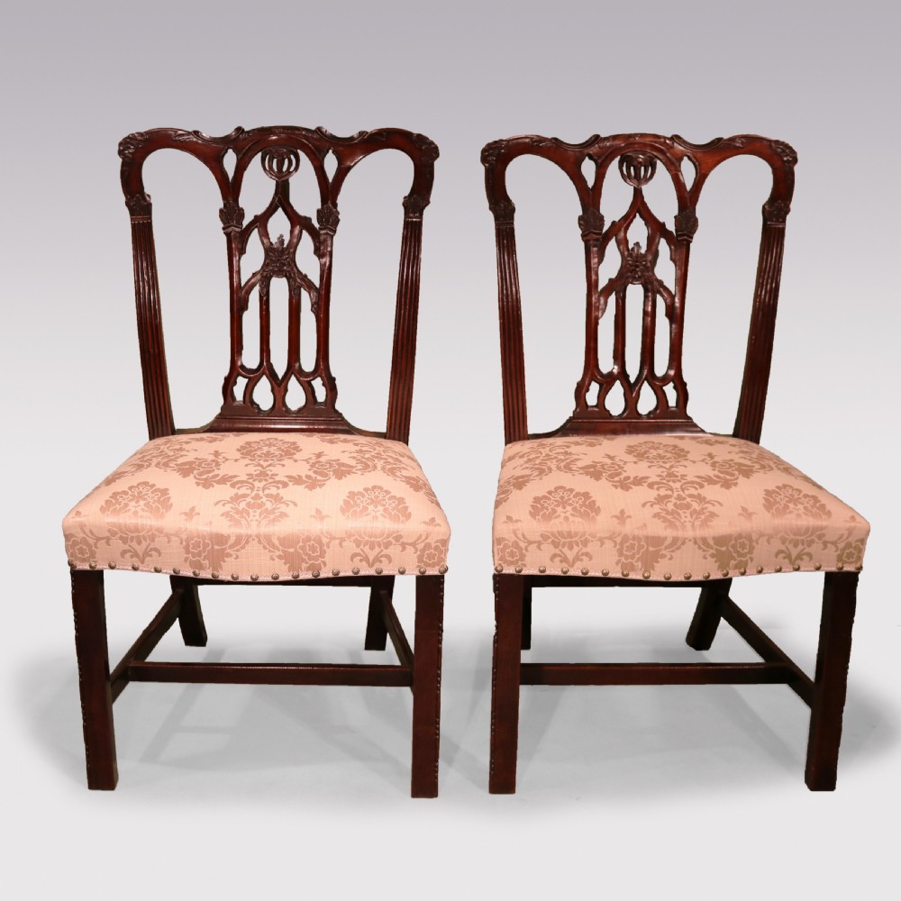 A set of twelve mid-nineteenth-century mahogany dining chairs with pierced Gothic tracery back splats and upholstered damask seats. View VI