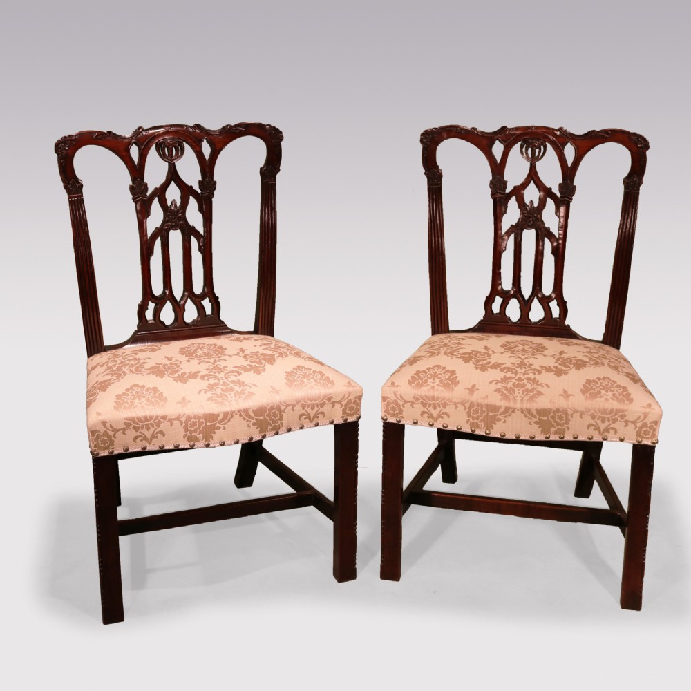 A set of twelve mid-nineteenth-century mahogany dining chairs with pierced Gothic tracery back splats and upholstered damask seats. View VII