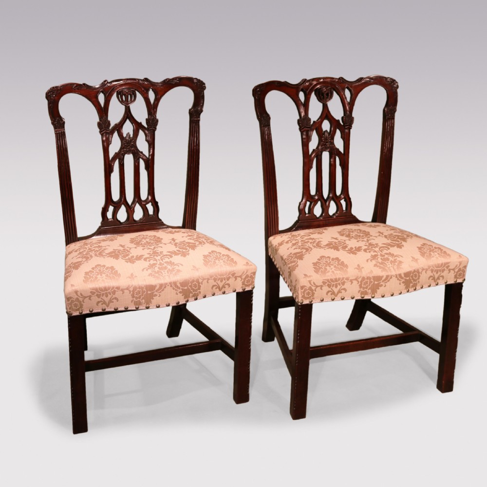A set of twelve mid-nineteenth-century mahogany dining chairs with pierced Gothic tracery back splats and upholstered damask seats. View VIII