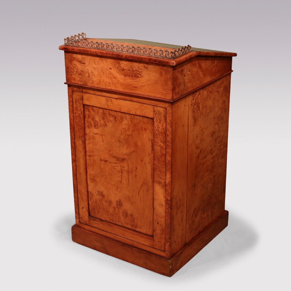 A mid 19th century burr elm Davenport desk featuring a green leather writing slope, brass gallery rail, and four stacked drawers. View VI