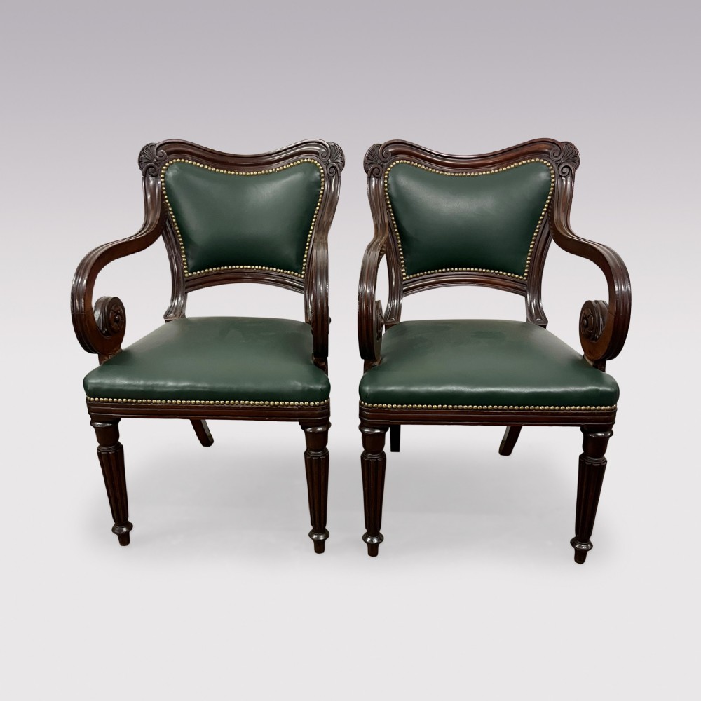 A set of ten Victorian mahogany dining chairs upholstered in forest green leather with brass stud trimming, featuring turned reeded legs and scrollwork carved backs, including two carver armchairs. View III
