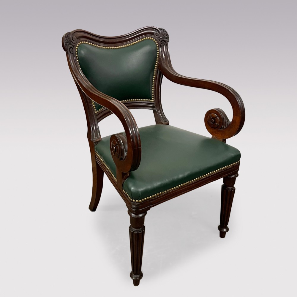 A set of ten Victorian mahogany dining chairs upholstered in forest green leather with brass stud trimming, featuring turned reeded legs and scrollwork carved backs, including two carver armchairs. View IV