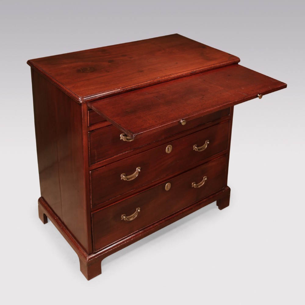 An antique George II mahogany chest of drawers with two short over three long drawers, brass swan-neck handles, bracket feet, and a pull-out brushing slide. View III