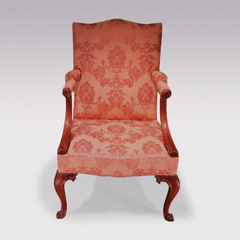 A George III mahogany Gainsborough library armchair upholstered in terracotta floral damask fabric with carved arm supports and cabriole legs. View II