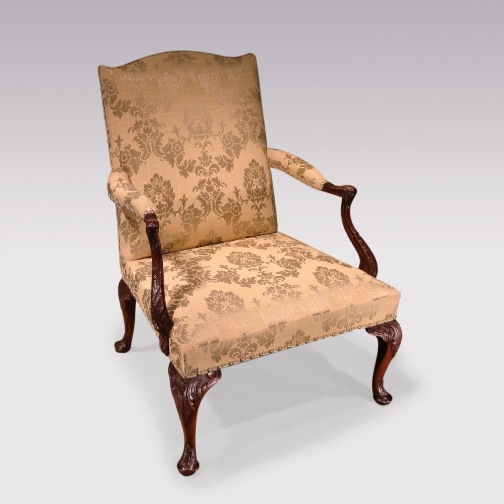 A pair of 19th-century Chippendale revival Gainsborough library armchairs upholstered in patterned gold damask fabric with carved mahogany frames and cabriole legs. View II