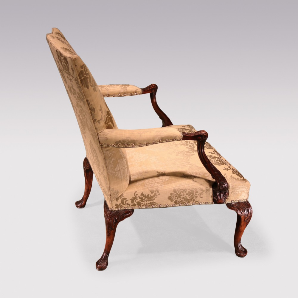 A pair of 19th-century Chippendale revival Gainsborough library armchairs upholstered in patterned gold damask fabric with carved mahogany frames and cabriole legs. View III
