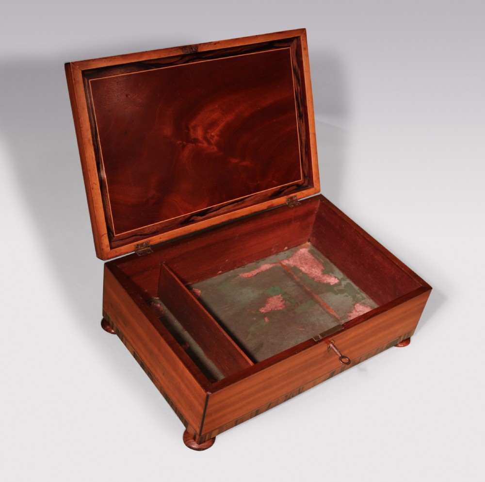 A rectangular George III satinwood box featuring a central oval shell marquetry inlay, fan corner motifs, and striped calamander crossbanding. View II
