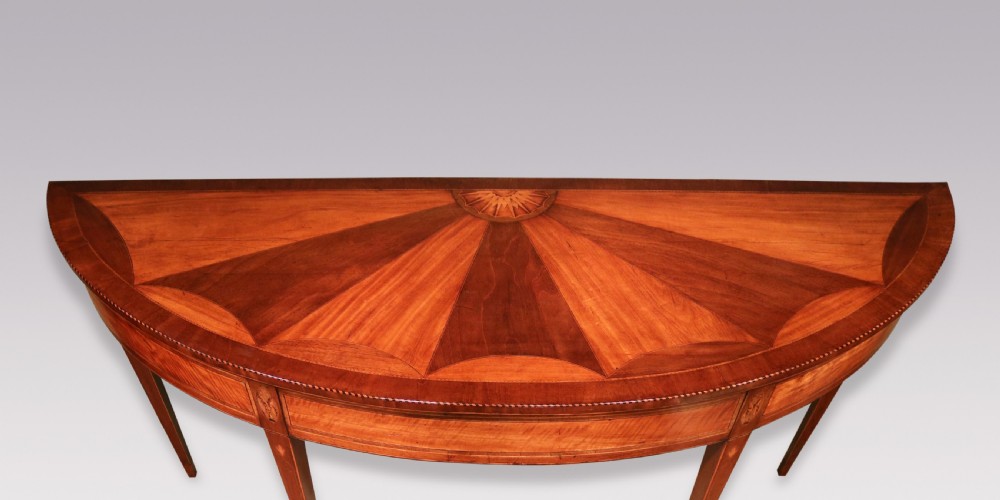A semi-circular George III satinwood and padoukwood console table featuring a sunburst inlaid top and square tapered legs. View III