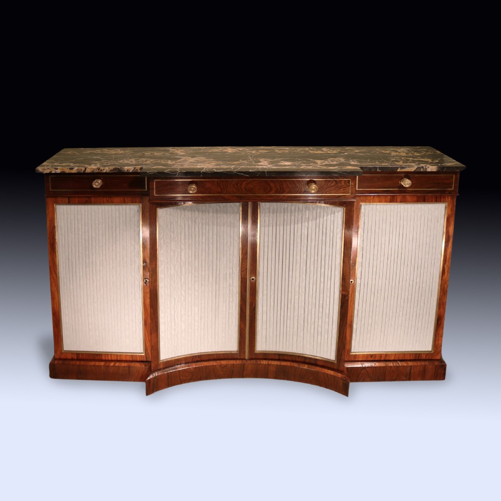 A Regency period rosewood chiffonier featuring a dark marble top, upper drawers with turned knobs, and pleated fabric panelled breakfront doors. View III