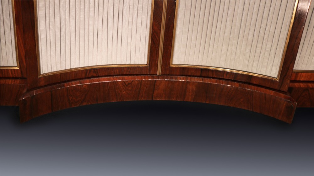 A Regency period rosewood chiffonier featuring a dark marble top, upper drawers with turned knobs, and pleated fabric panelled breakfront doors. View V