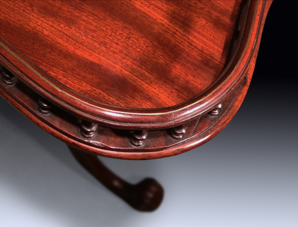 A George III mahogany tripod table featuring a rectangular serpentine top with a pierced spindle gallery on a carved pillar and cabriole legs. View III