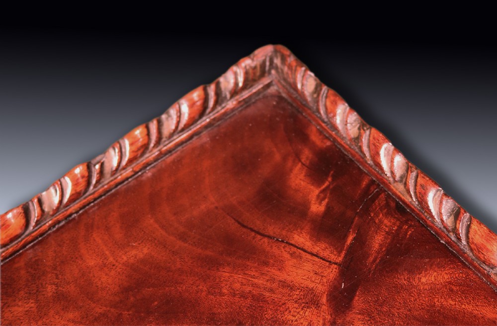 An antique George III mahogany kettle stand featuring a square tray top with a gallery rim, a pull-out slide, a spiral-carved column, and a tripod base. View IV