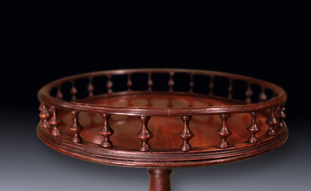 An 18th-century George III mahogany kettle stand featuring a circular top with a spindled gallery rim, supported by a turned column and tripod cabriole legs with pad feet. View IV