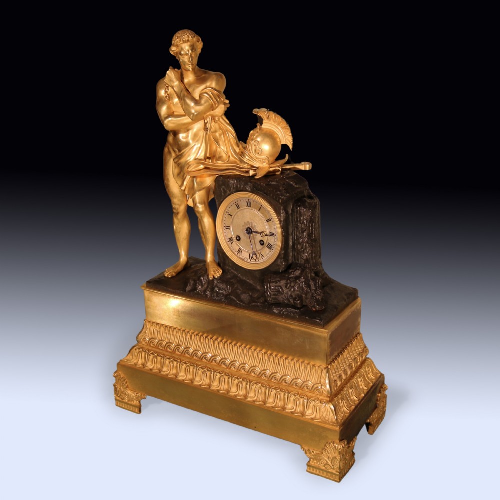 An early 19th-century French Empire gilt bronze and ormolu mantel clock featuring a sculpted classical figure standing beside a dark bronze movement casing. View II