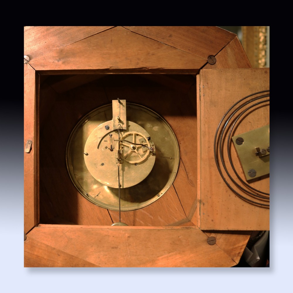 An octagonal nineteenth-century French rosewood wall clock decorated with floral marquetry inlay, a silvered dial with Roman numerals, and a top brass hanging ring. View IV