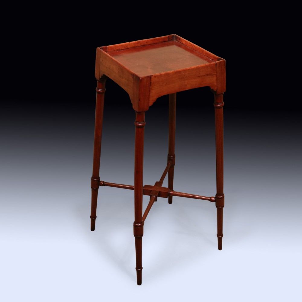 A tall George III mahogany urn stand featuring a square galleried top, slender turned legs, and a central X-stretcher.