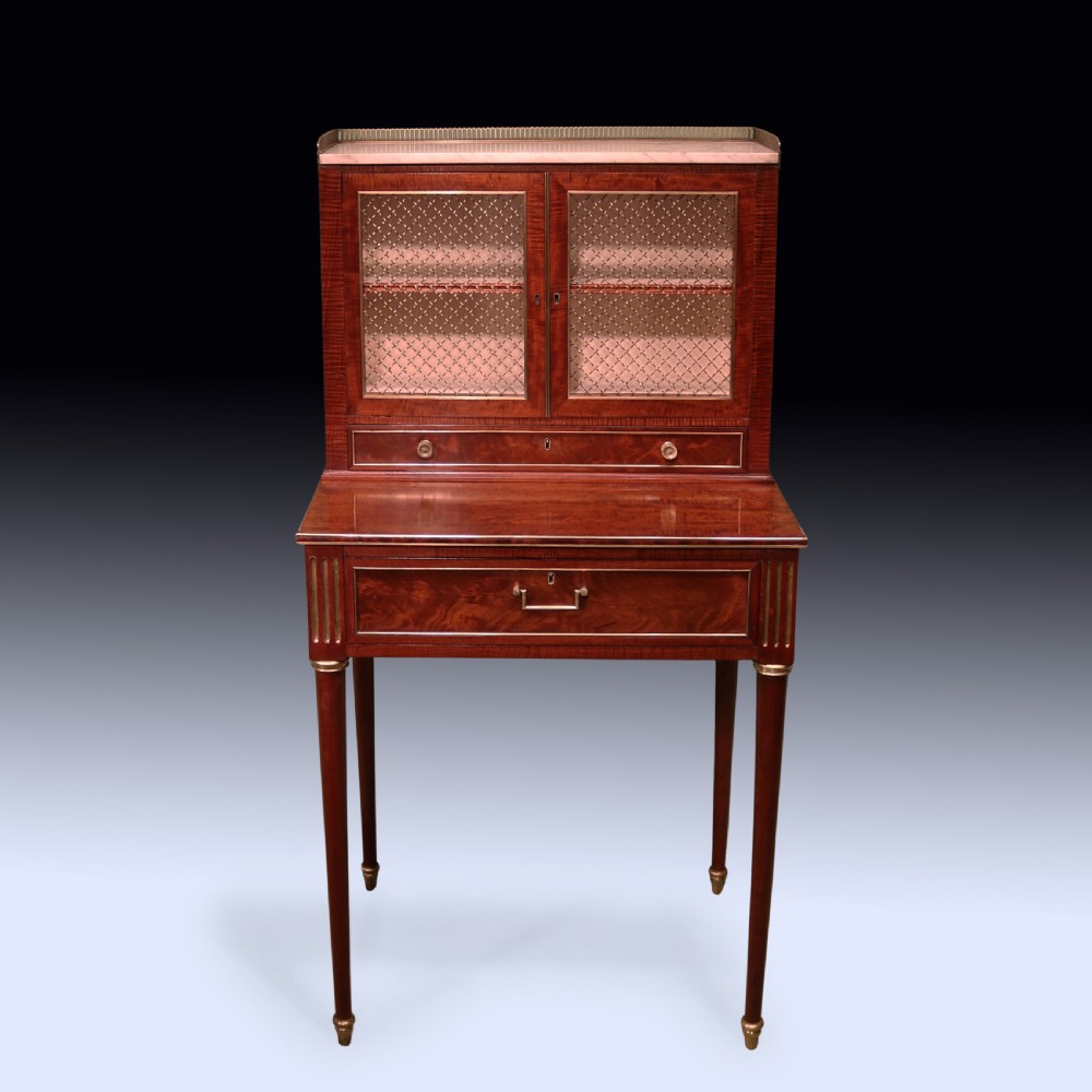 A pair of Regency period mahogany bonheur du jours featuring brass wire grille cabinet doors, marble tops, and slender turned legs. View III