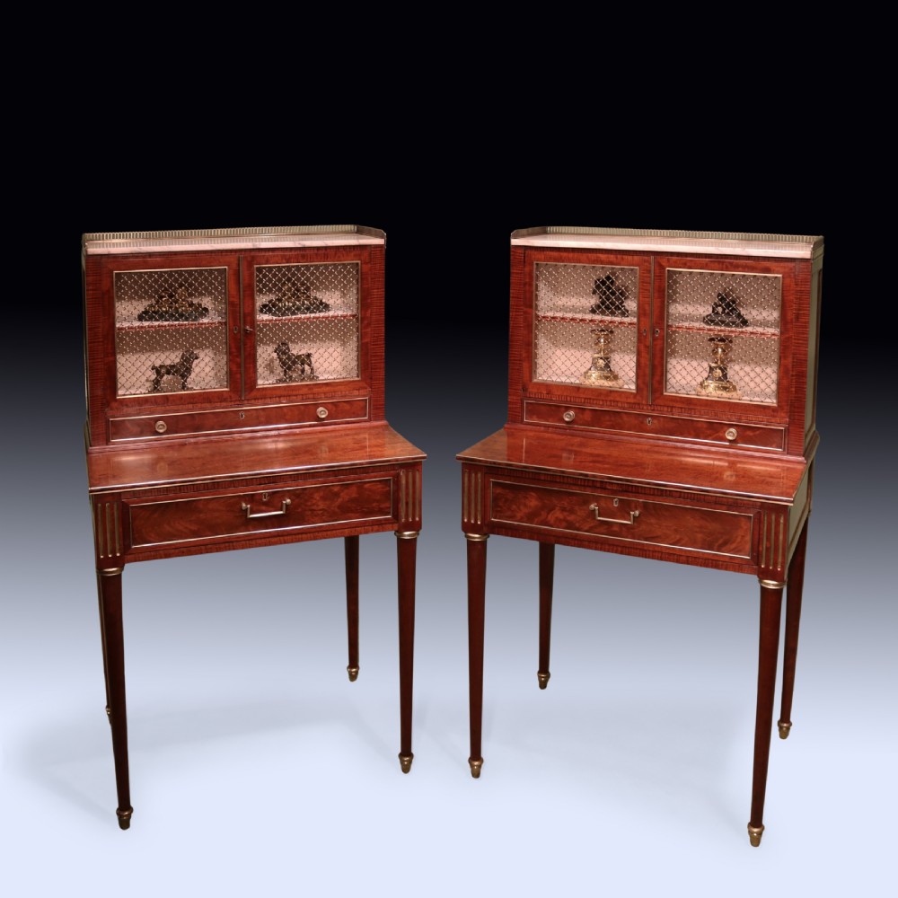 A pair of Regency period mahogany bonheur du jours featuring brass wire grille cabinet doors, marble tops, and slender turned legs. View VI