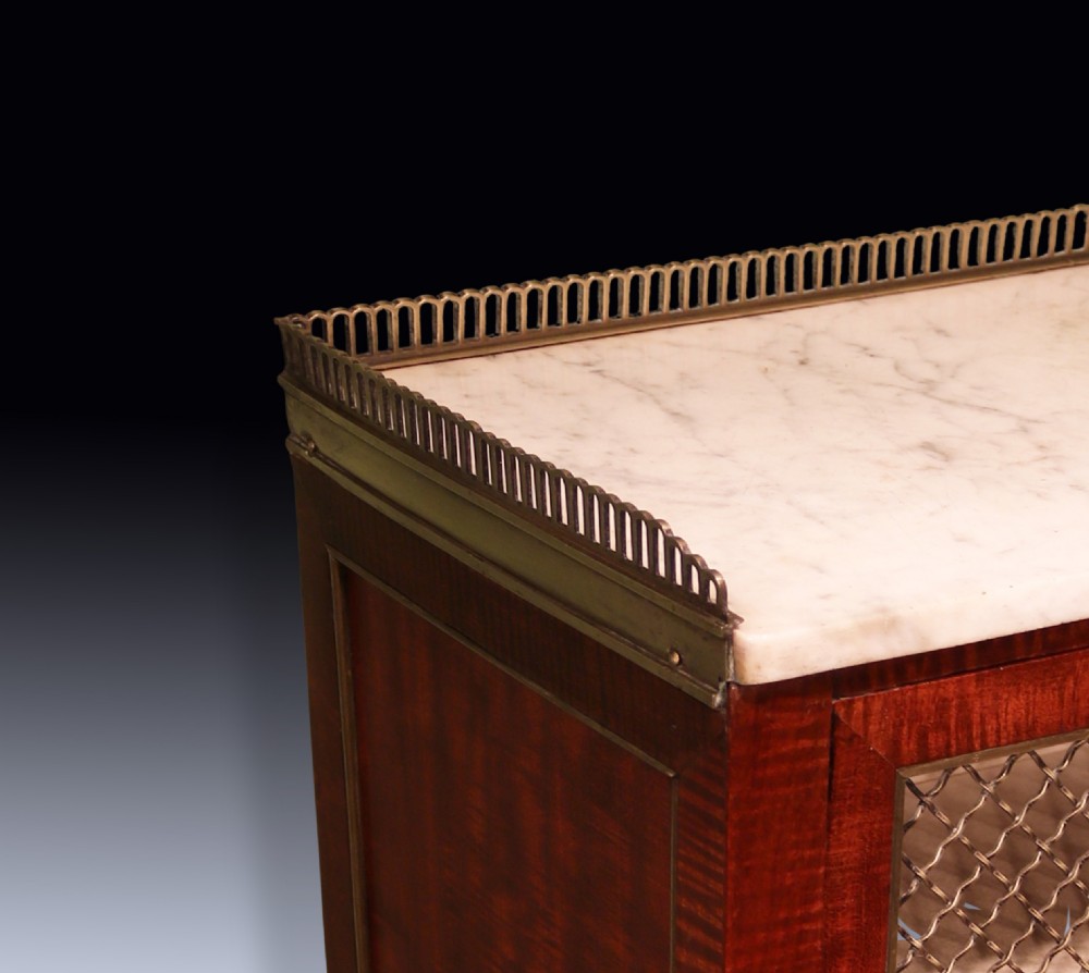 A pair of Regency period mahogany bonheur du jours featuring brass wire grille cabinet doors, marble tops, and slender turned legs. View IX